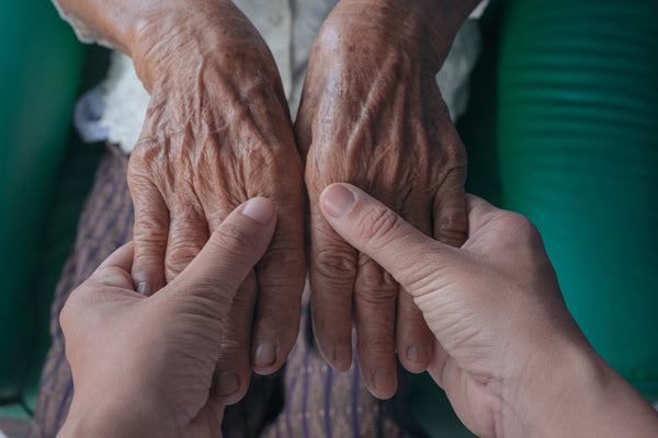 Young woman holding an elderly woman's hand
