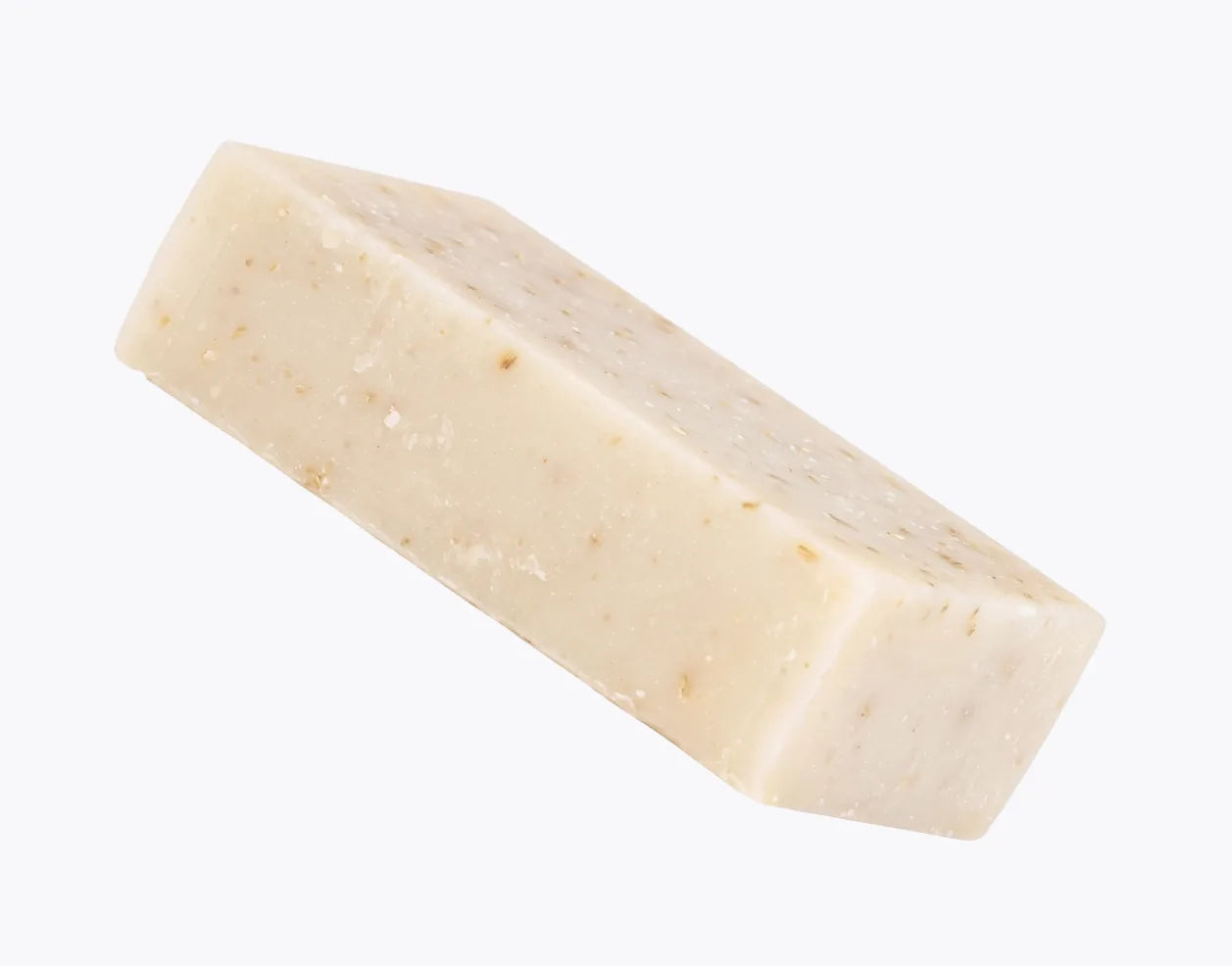 The Emu Joy oatmeal soap bar angled on a pale grey background, flecks of Scottish oat kernel meal visible through the bar