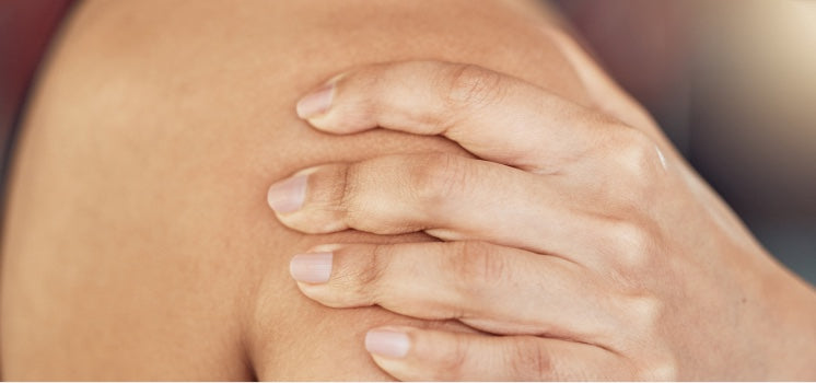Hand resting on a bare shoulder, as if easing a sore muscle