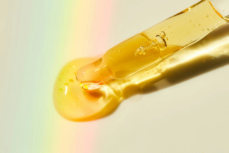 Dropper releasing a drop of golden emu oil