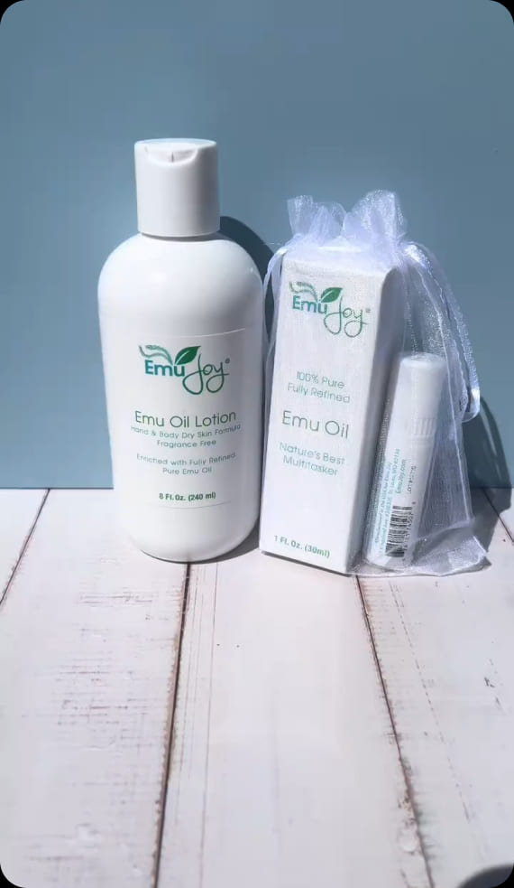 Emu Joy Emu Oil Lotion beside a boxed 1 fl oz Emu Oil in an organza gift bag